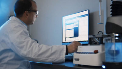 man in lab coat working looking at computer