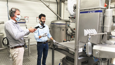 deux personnes debout près d'une machine