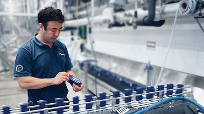 Tetra Pak operator reviewing Tetra Pak cartons on conveyor line