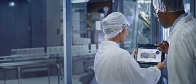 Two people looking at tablet showing the heat pump system