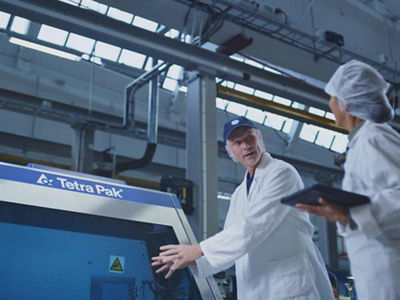 Arbeiter in Tetra Pak Fabrik vor Homogenisator