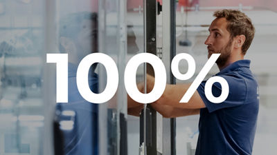 Technician working inside an industrial machine, overlaid with “100%”