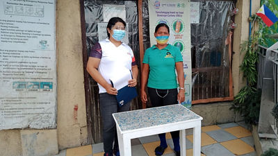 Kayıt listesi olan bir hurda dükkanının önündeki kadınlar