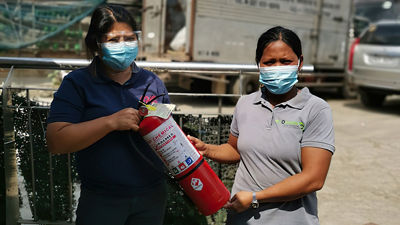 Temalı bir ödülün parçası olarak bir yangın söndürücü tutan kadınlar