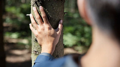 Girl with hand on tree