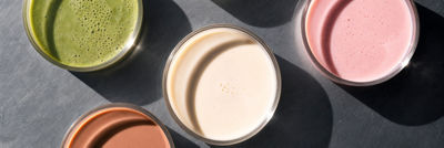 Petri dishes containing colourful plant-based samples on a stainless steel surface.