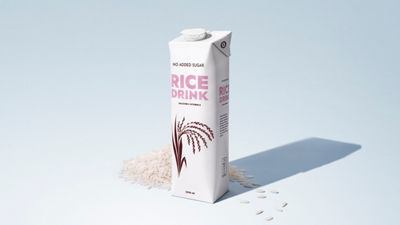 Carton of plant-based rice drink surrounded by rice grains on a light blue background.