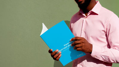 Person wearing a pink shirt holding a blue Tetra Pak white paper about plant-based yoghurt-style products.