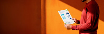 Person reading a Tetra Pak infographic about reducing waste and raw material use