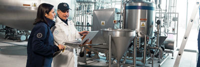 Workers inspecting industrial processing tank