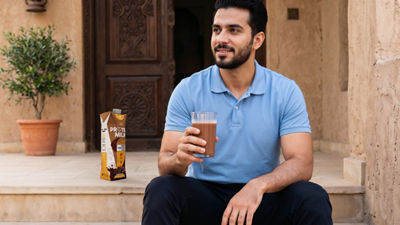 Young man with computer, protein milk in Tetra Prisma Aseptic carton package