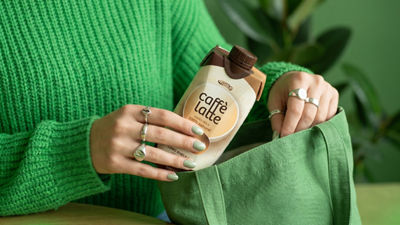 Puts a carton of RTD coffee in her handbag