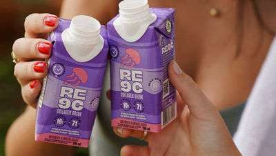 Mãos femininas seguram embalagens roxas da bebida de colágeno RE9C com tampa branca, destacando 10g de colágeno, 71 calorias e o selo “beba gelado”.