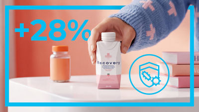 Hand holding Tetra Prisma carton, text: 28%