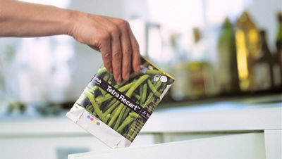 Someone holding empty carton over recycling bin