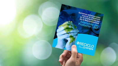 A hand holding a recycling information folder