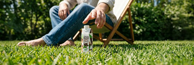 Sitting in a deck chair, reaching for iced coffee in carton package