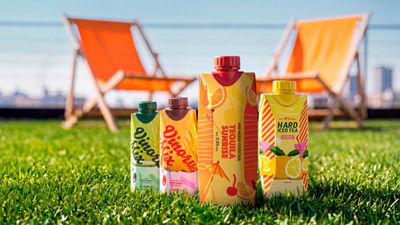 RTD alcoholic beverages in carton on the grass with beach chairs in the background