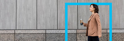 Woman walking, coffee drink in Tetra Top carton bottle, blue frame