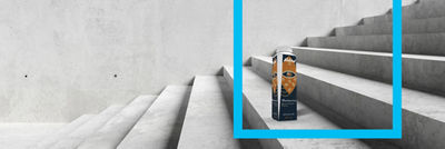 Coffee in Tetra Top carton standing on the stairs, blue frame