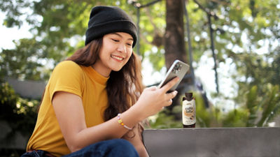 Girl looking at phone, rtd coffee beverage carton