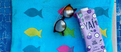 RTD tea Yai packages on towel and sunglases