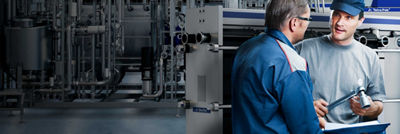 Tetra Pak service engineers in front of heat exchangers