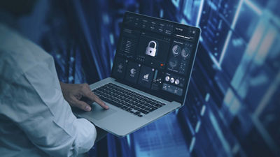 Man holding laptop with padlock on screen