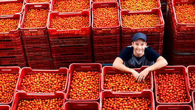 Man amoung crates of fruit