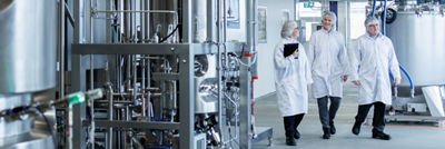 People walking in Tetra Pak production discussing self stablilising simplicity.