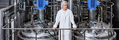 Woman standing in production hall looking out