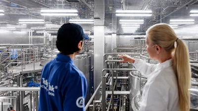 Tetra Pak employees, processing equipment in background