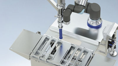 Closeup of robot arm with filling nozzle on a Tetra Pak Ice Cream Robot Filler M2 equipment