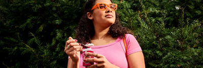 Person eating yoghurt from a Tetra Reva package outdoors.
