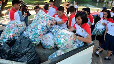 Thai students loading flattened cartons onto lorry