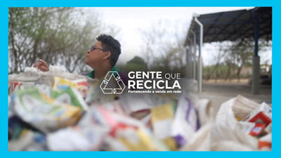 Pessoa atua em ponto de reciclagem com materiais separados em primeiro plano, representando a cadeia de reciclagem da Tetra Pak Brasil.