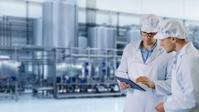 two factory workers looking at screen