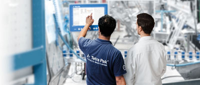 Dois homens olhando para a tela na fábrica de embalagens