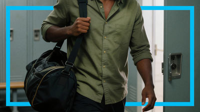 Man at gym holding a bag.