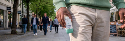 Walking on street holding recovery drink in Tetra Prisma carton in his hand
