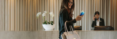 Woman at hotel desk with carton in hand