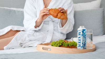 Woman in robe eating a croisant