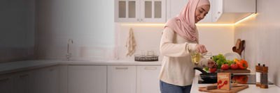 Woman cooking, chopped tomatoes in Tetra Recart carton package