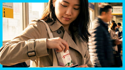 Woman holding iced tea package.