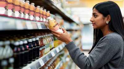 Woman in store holding and reading on carton package