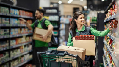 Store staff unpacking groceries, Tetra Recart cartons on shelf