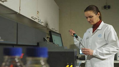 Woman using pipette in laboratory