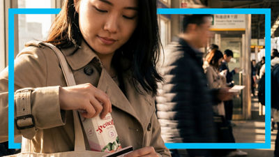 Woman holding iced tea package.