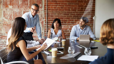 Reunião em sala com diversos trabalhadores e trabalhadoras