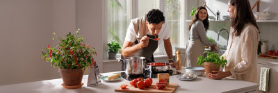 Family in kitchen cooking, tomato products in Tetra Recart carton packages